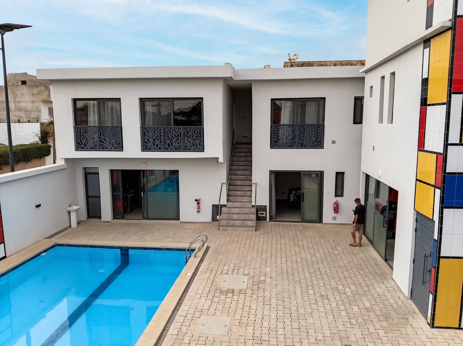 Vue de la cour intérieure du Mondrian avec la piscine, les chambres et le bandeau coloré de la façade.